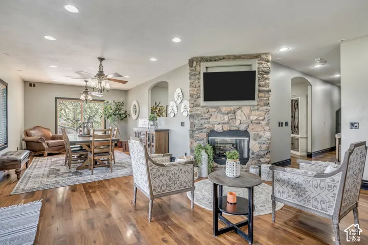 Open-concept interior featuring wood-finish flooring, recessed lighting, and a floor-to-ceiling stone fireplace