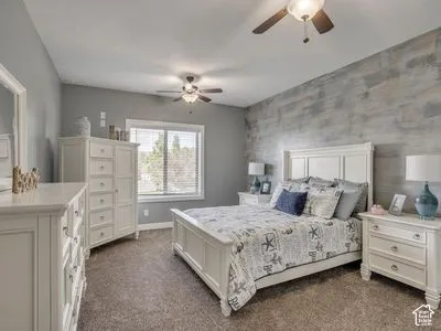 Room featuring wood-finish wall paneling, wall-to-wall carpeting, and dual ceiling fans