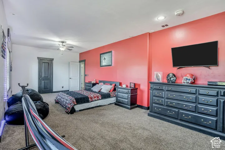 Spacious room featuring carpeting, recessed lighting, a ceiling fan, and bold accent wall painting