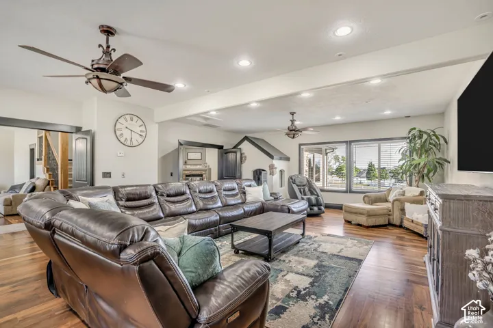 Wood-finish flooring, recessed ceiling lighting, two dual-blade ceiling fans, and expansive windows