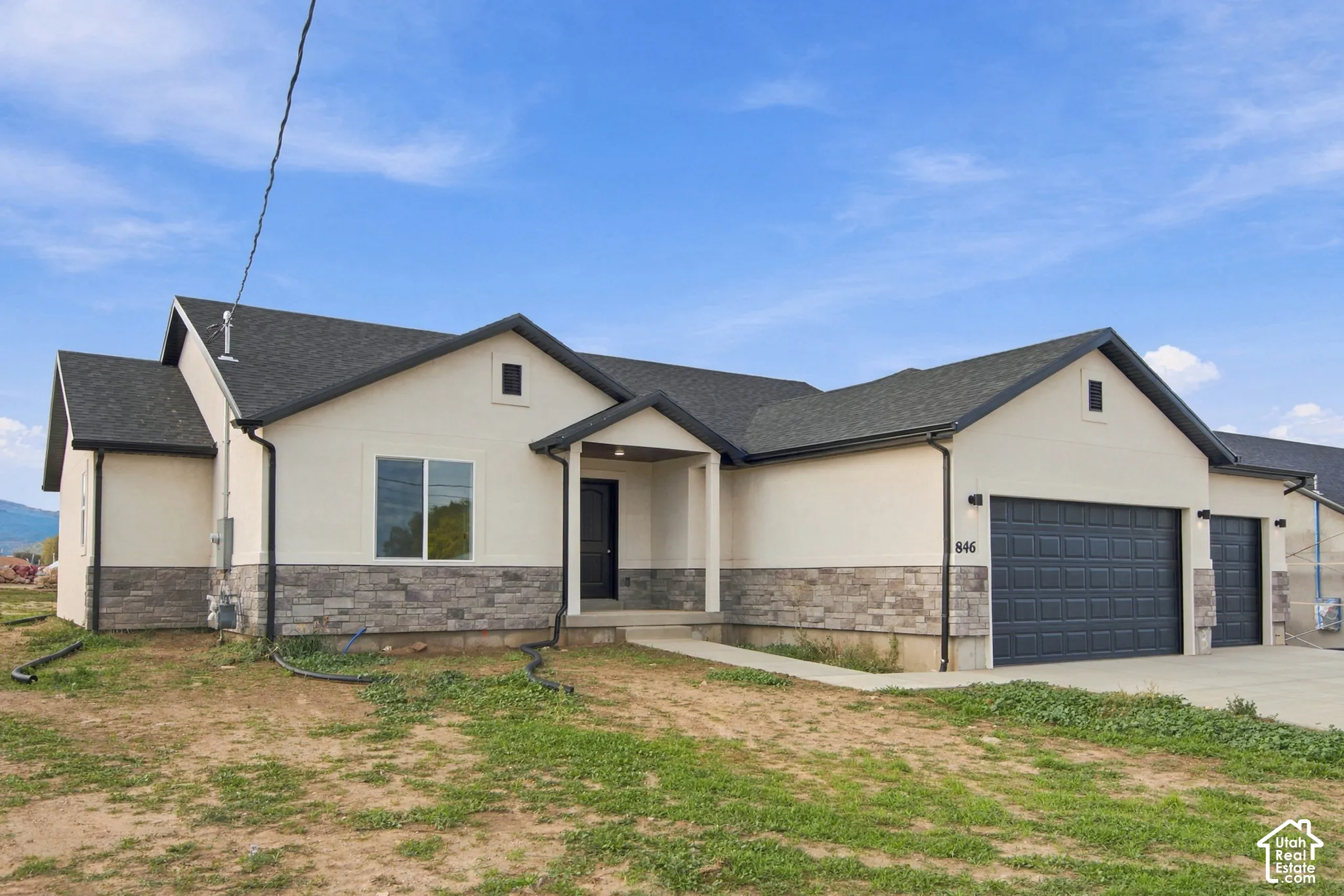 Exterior featuring stucco siding, stone veneer accents, an asphalt shingle roof, and a three-car garage