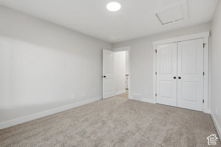 Neutral-toned wall-to-wall carpeting, recessed ceiling lighting, and double-door closet with arched-panel detailing