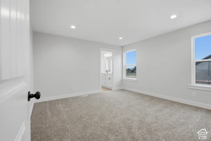 Neutral-toned carpet, recessed ceiling lighting, two double-hung windows, and crisp wall finishes