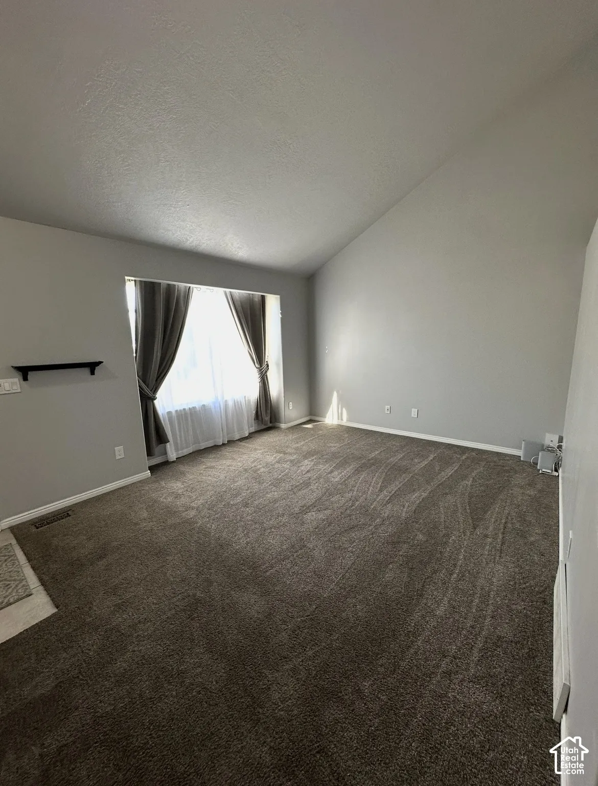 Vaulted ceilings, expansive picture window, and neutral wall tones