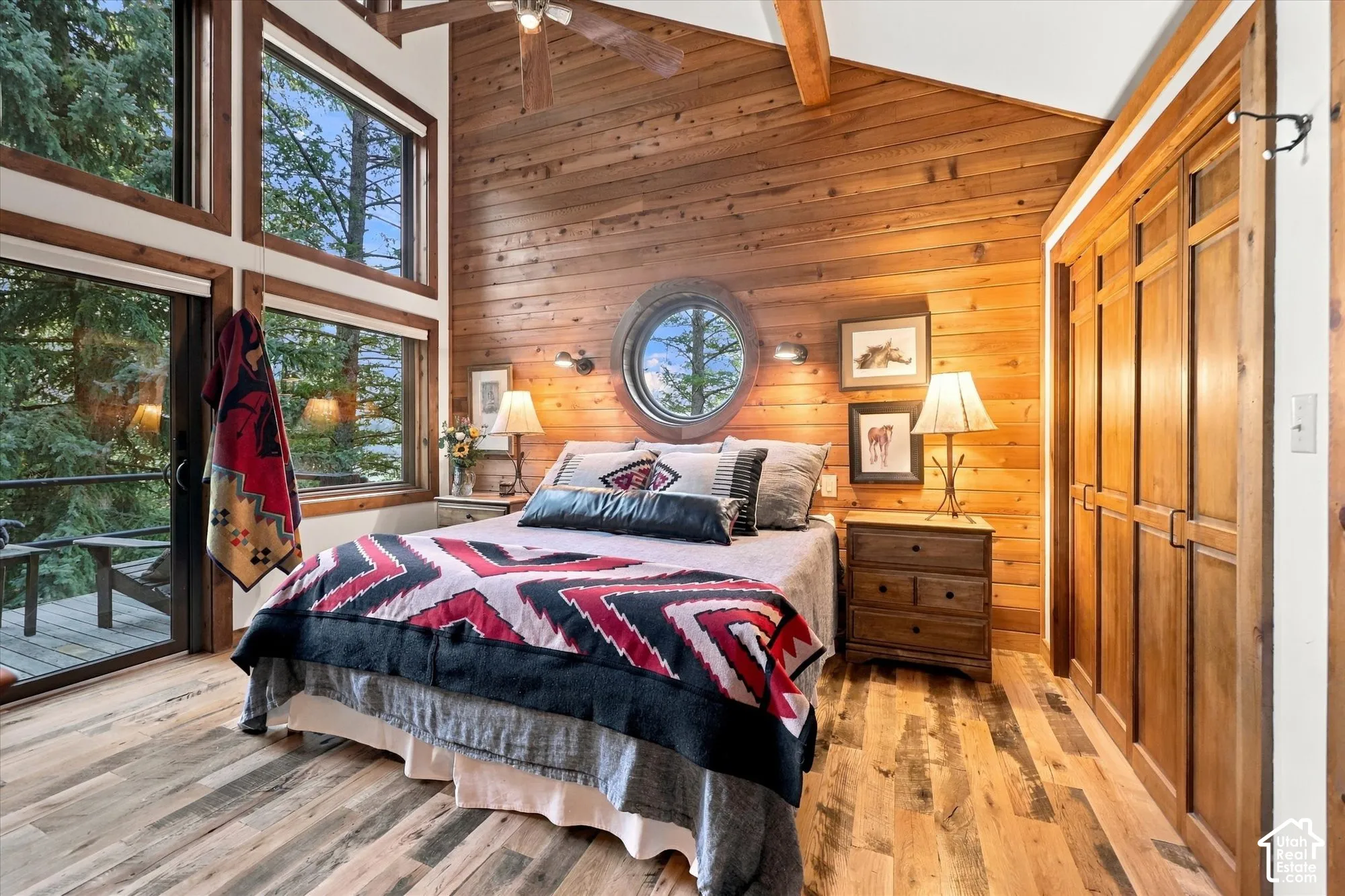 Spacious master bedroom with mountain views from wall of windows, plus round window above bed