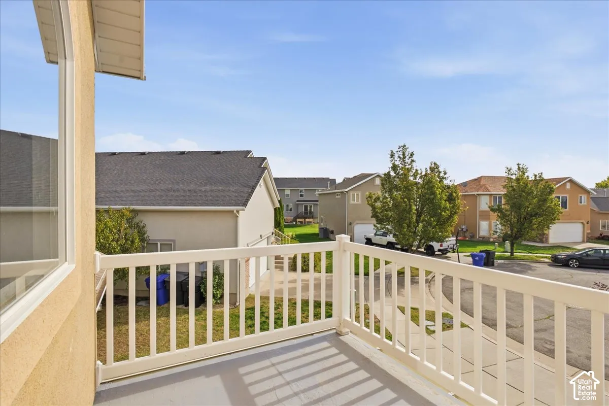 Elevated balcony featuring white vinyl railing and neutral-toned decking