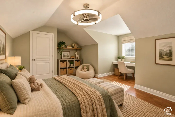 Vaulted ceiling featuring a modern drum-style chandelier with an integrated ceiling fan, built-in desk under a recessed window, and wood-finish flooring