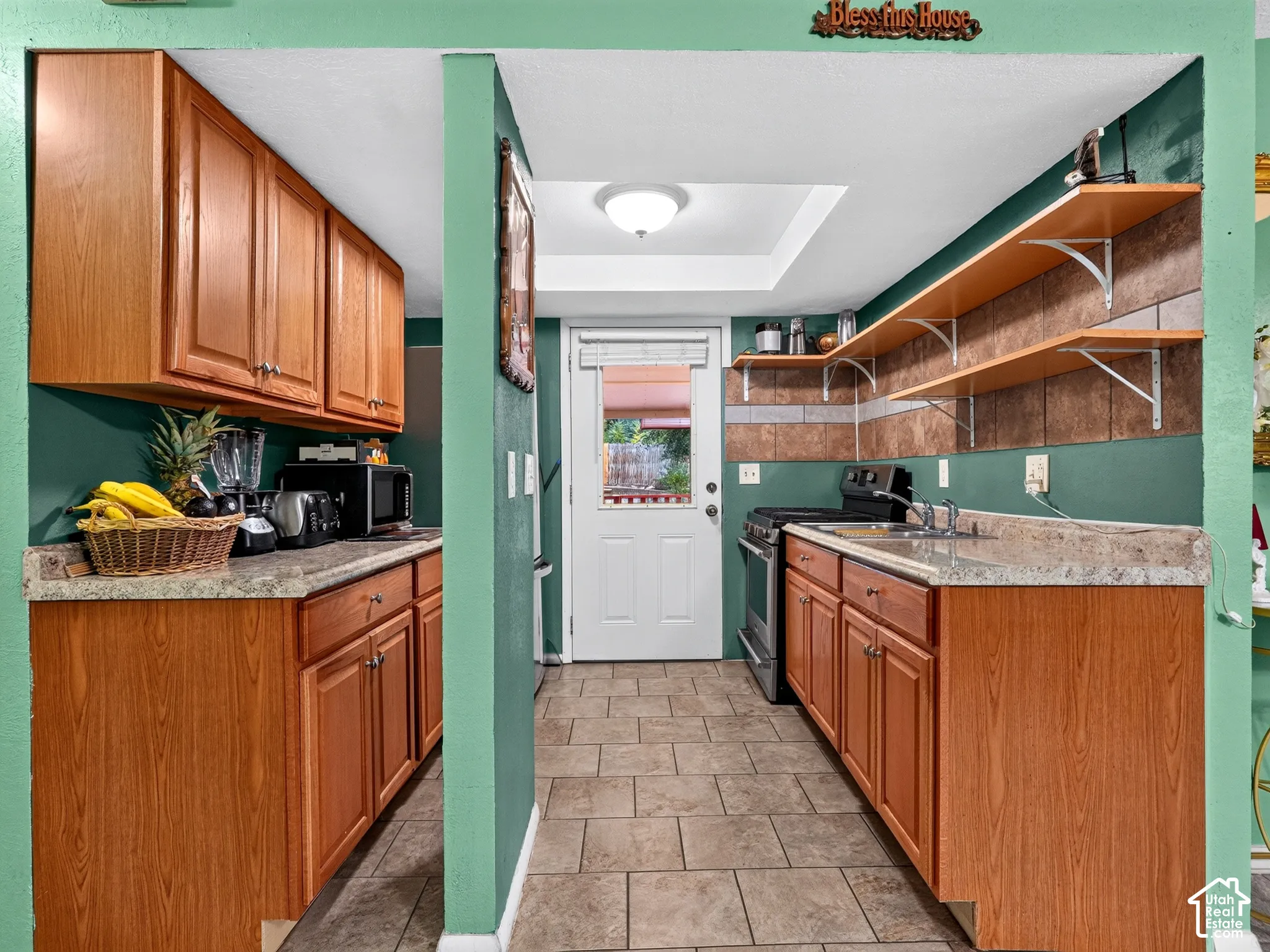 2 bedroom unit - Kitchen featuring wood cabinetry, stone-finish countertops, ceramic tile flooring, tile backsplash, and open shelving