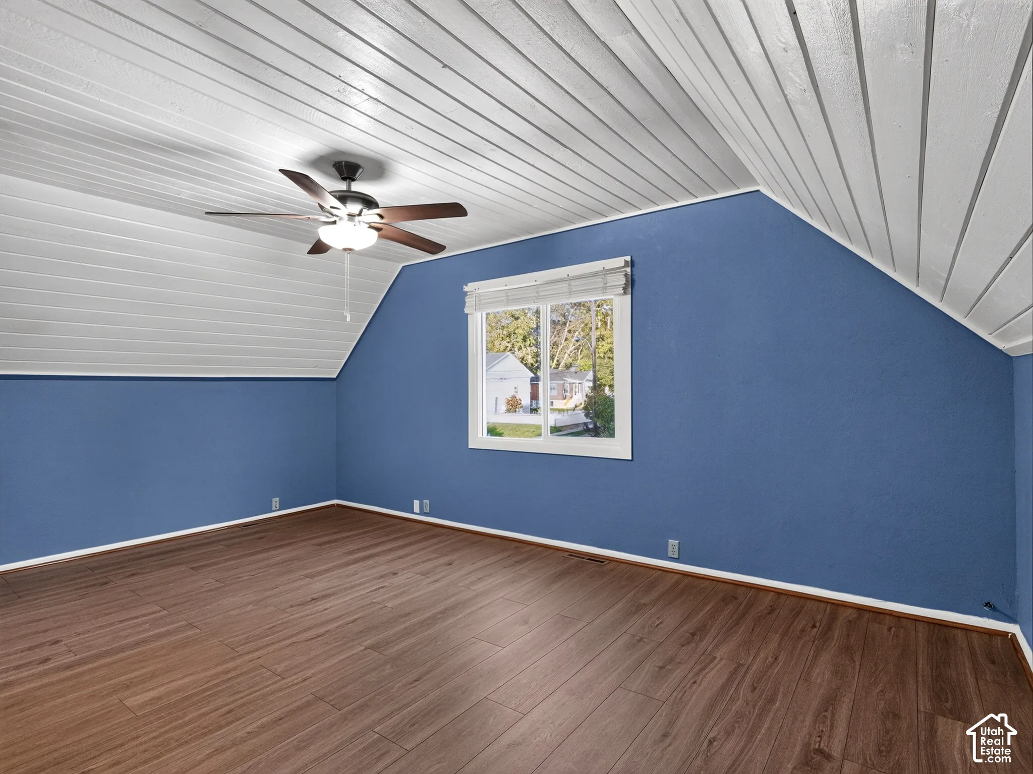 1 bedroom unit - Loft/living room/Interior space featuring vaulted wood-paneled ceilings, wood-finish flooring, a centrally mounted ceiling fan, and a single-pane window