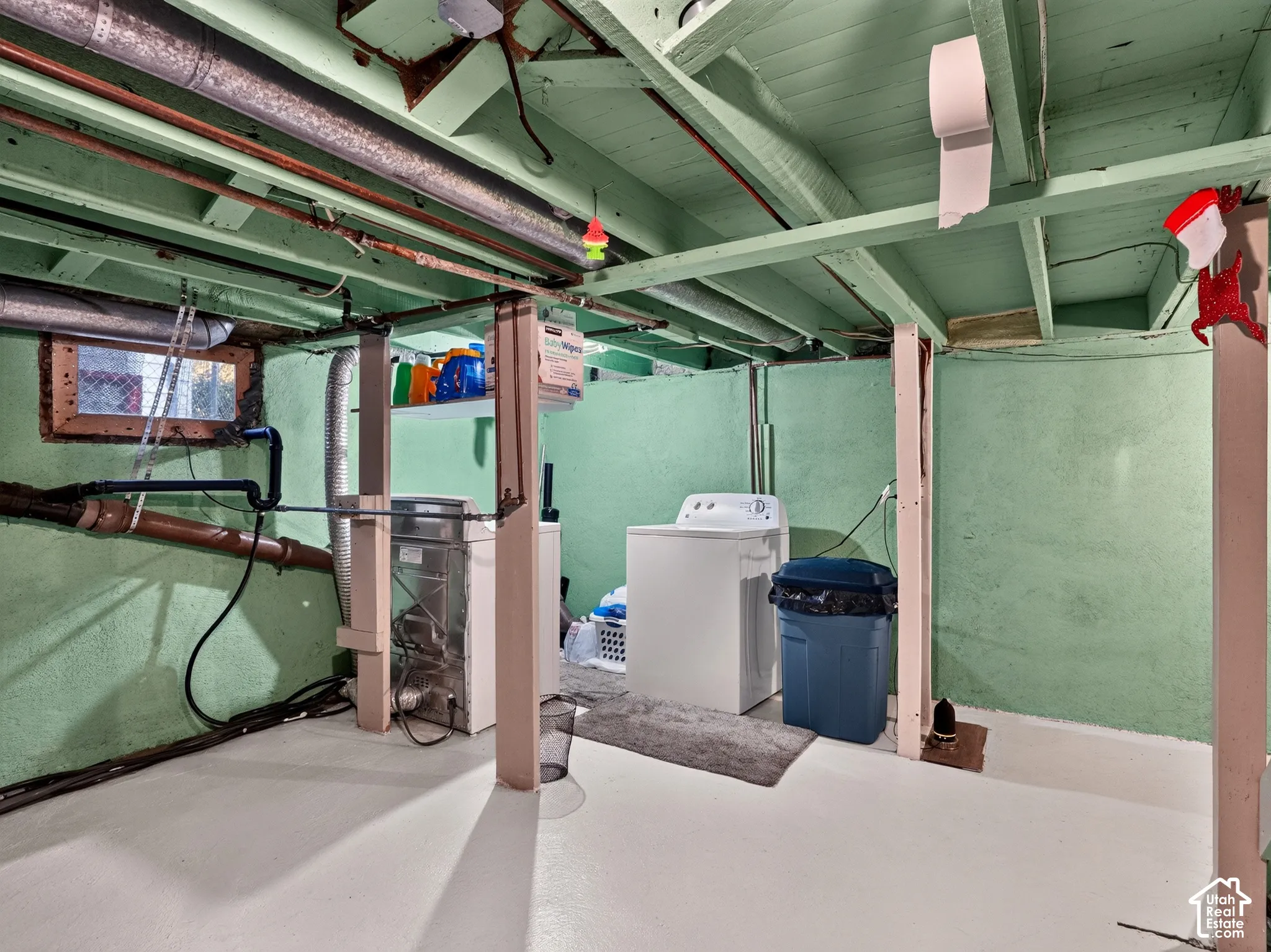 Basement - Utility space featuring exposed structural joists, painted concrete walls, painted flooring, and a single-pane hopper window
