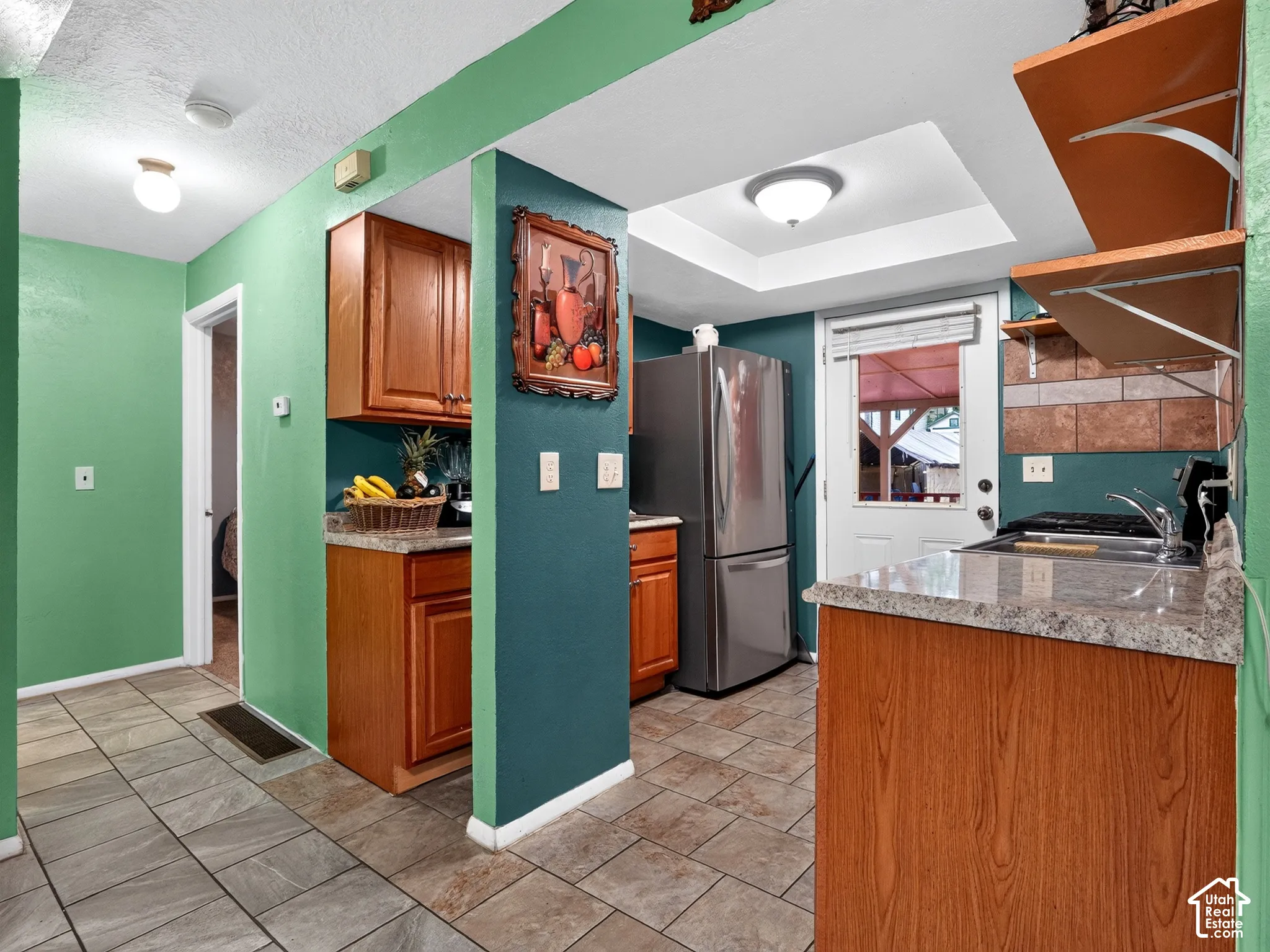 2 bedroom unit - Kitchen featuring wood cabinetry, stone-finish countertops, stainless steel refrigerator, recessed lighting, and tile flooring