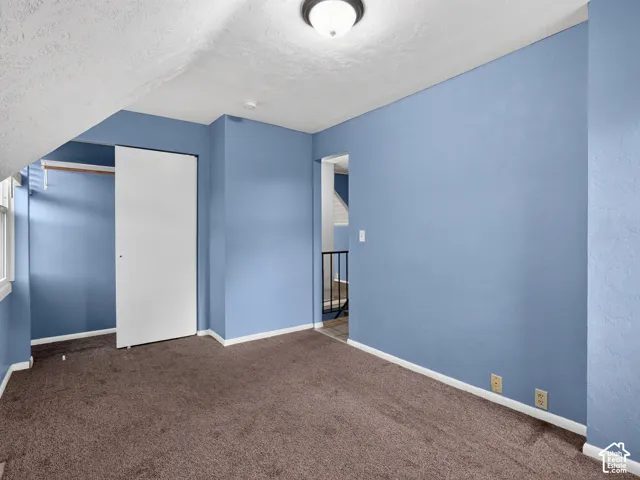 1 bedroom unit - Bedroom featuring vaulted ceilings, wall-to-wall carpeting, and a built-in closet with sliding doors