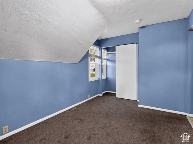 1 bedroom unit - Bedroom featuring a sloped ceiling, wall-to-wall carpeting, and a built-in closet with sliding doors