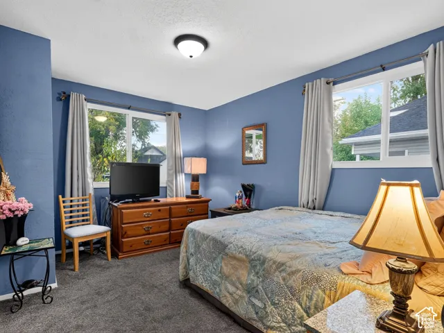 2 bedroom unit - Bedroom 2 Interior space featuring dual-aspect vinyl windows, wall-to-wall carpeting, and a flush-mount ceiling light fixture