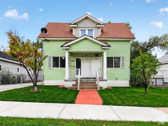 Two-story home with lap siding, a front-facing gable roof, a covered porch with tapered columns, and an upper-level dormer window