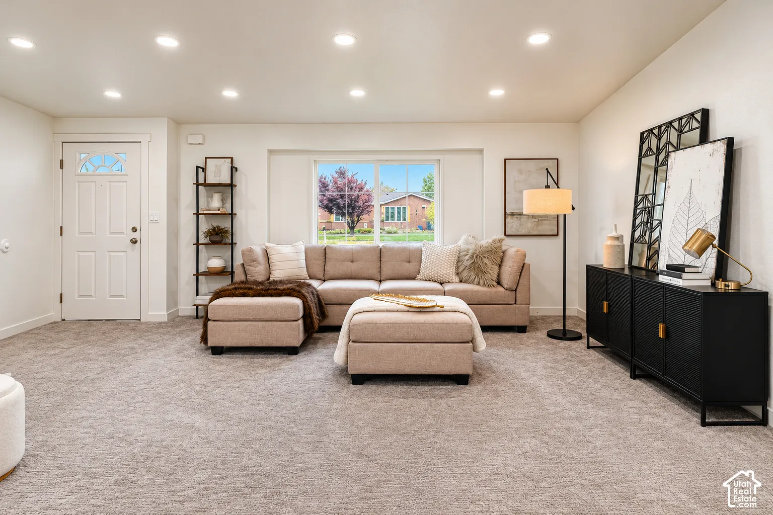 Neutral-toned carpeting, recessed ceiling lighting, and a large picture window