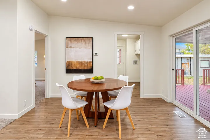Wood-finish flooring, neutral wall tones, recessed ceiling lighting, and sliding glass doors leading to an exterior deck