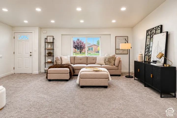Neutral-toned carpeting, recessed ceiling lighting, and a large picture window