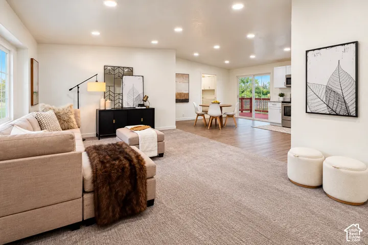 Open-concept interior featuring recessed lighting, wall-to-wall carpeting, wood-finish flooring, and sliding glass doors
