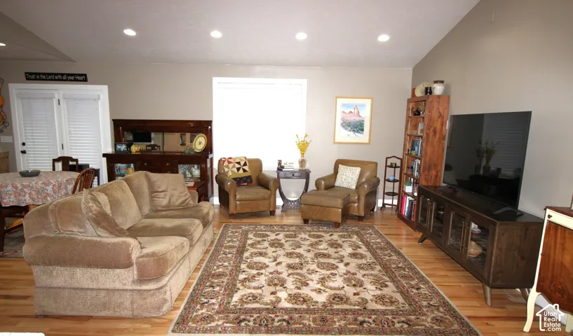 Vaulted ceiling featuring recessed lighting, Hickory  wood-finish flooring, and double glass-paned doors