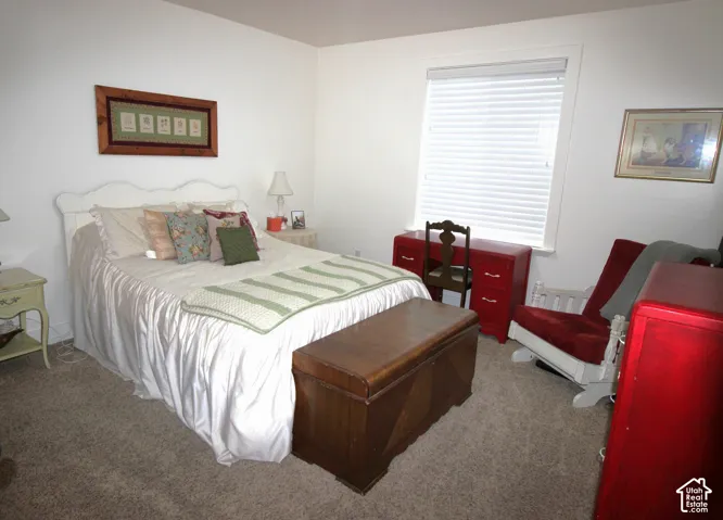 Guest Bedroom with Neutral-toned carpeted flooring, large window with integrated horizontal blinds, and smooth-finish white walls