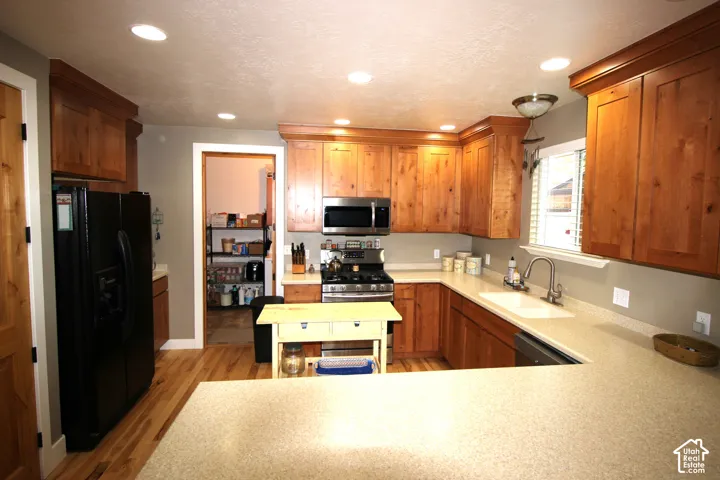 Kitchen featuring natural-finish wood cabinetry, solid-surface countertops, recessed lighting, wood-finish flooring, and electric range with convection oven
