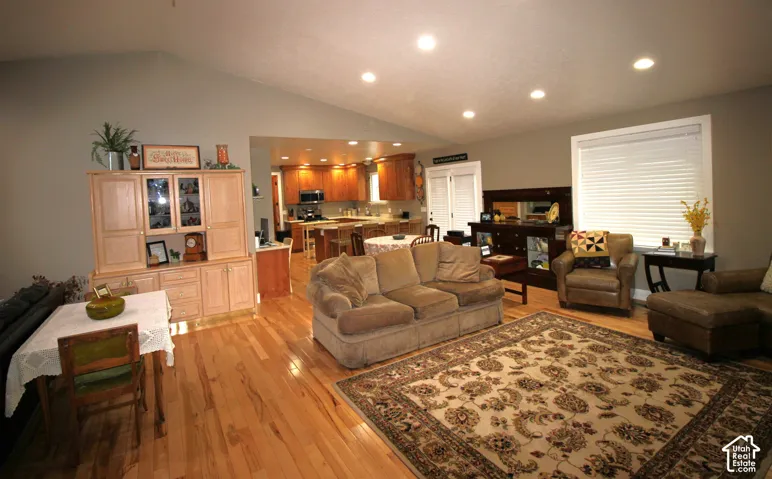 Great Room with Open-concept living space featuring vaulted ceilings, recessed lighting, wood flooring
