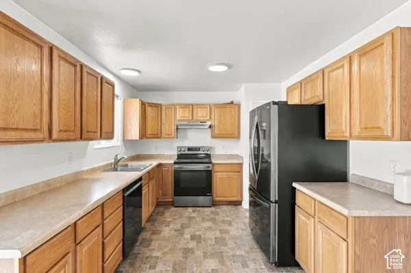 Kitchen featuring oak cabinetry, laminate countertops, stainless steel electric range, stainless steel range hood, and tile-finish flooring
