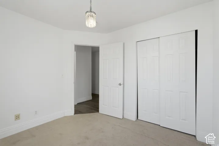 Neutral wall tones, wall-to-wall carpeting, six-panel interior doors, sliding closet doors, and a crystal-accented pendant light fixture