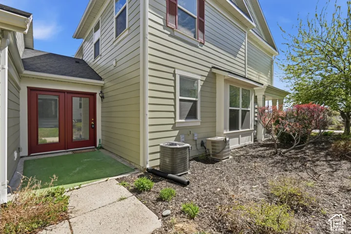 Horizontal lap siding exterior with red double-entry doors, window shutters, and a concrete paver walkway