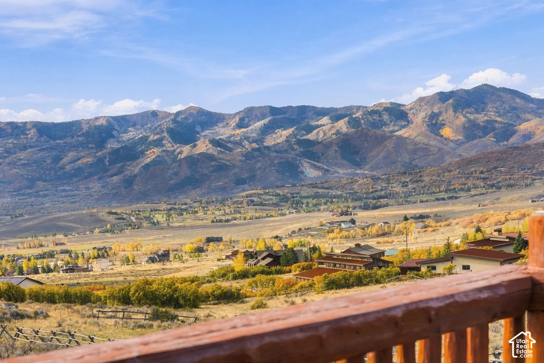 Elevated wooden railing overlooking a mountain landscape with expansive valley terrain
