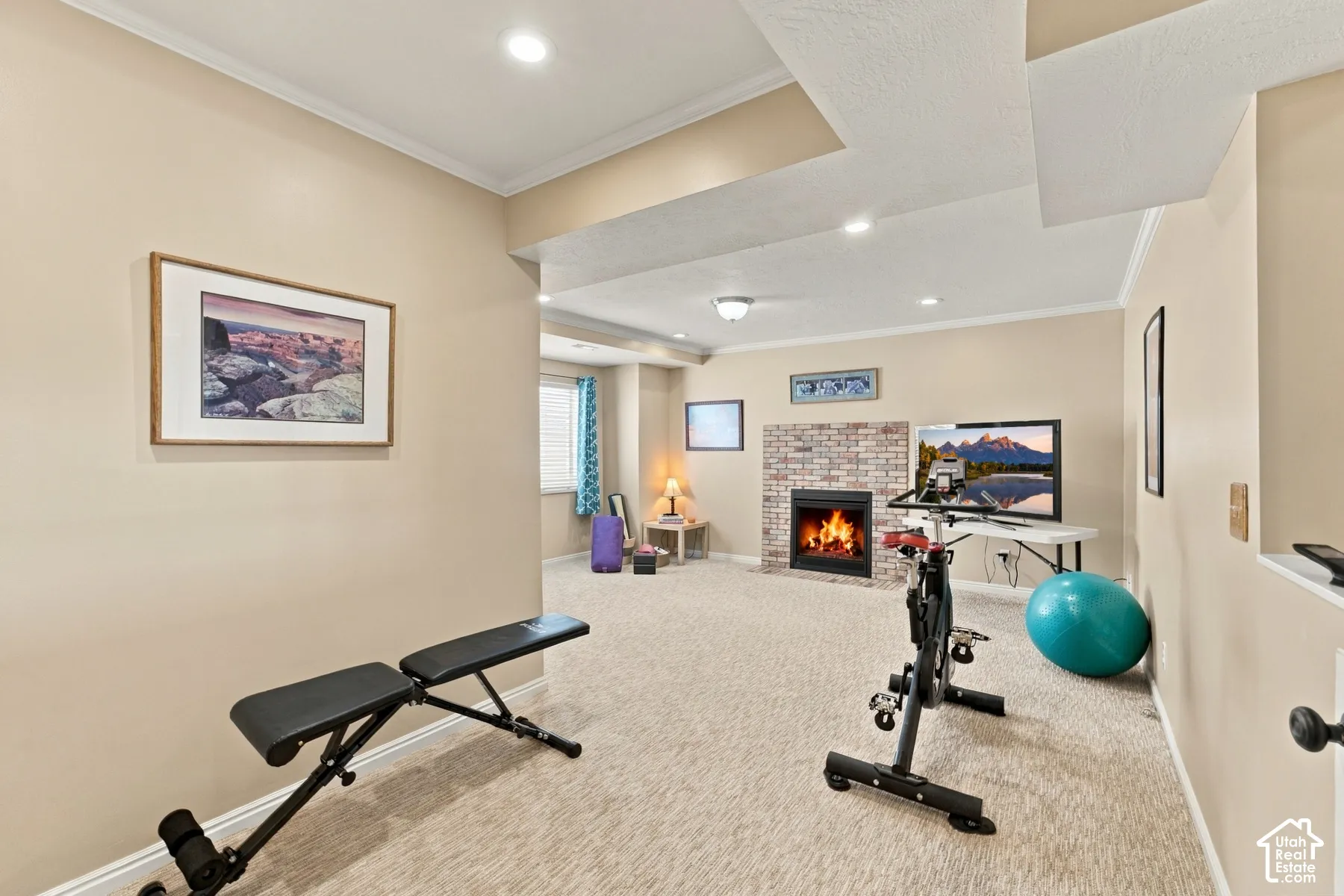 Neutral-toned interior space featuring recessed ceiling lighting, wall-to-wall carpeting, and a floor-to-ceiling brick-surround fireplace