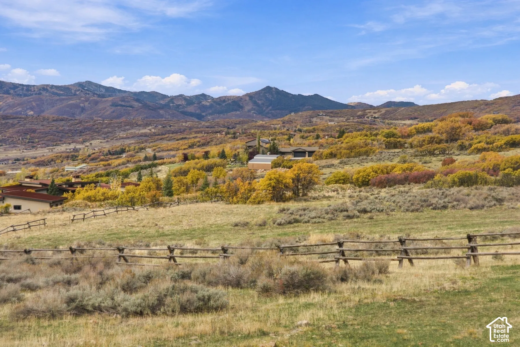 Expansive acreage featuring mountain topography, native high-desert vegetation, and post-and-rail timber fencing