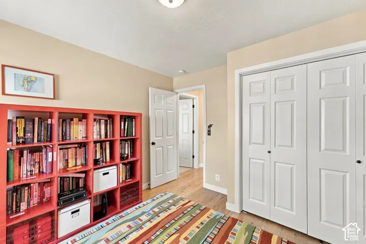 Room featuring wood-finish flooring, dual-panel closet doors, and solid-core interior doors