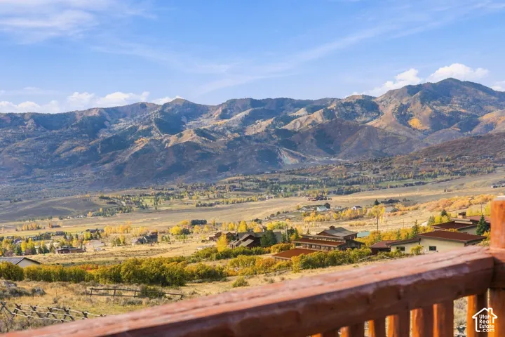 Elevated wooden railing overlooking a mountain landscape with expansive valley terrain