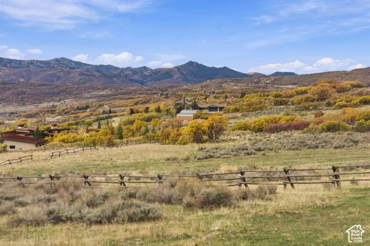 Expansive acreage featuring mountain topography, native high-desert vegetation, and post-and-rail timber fencing