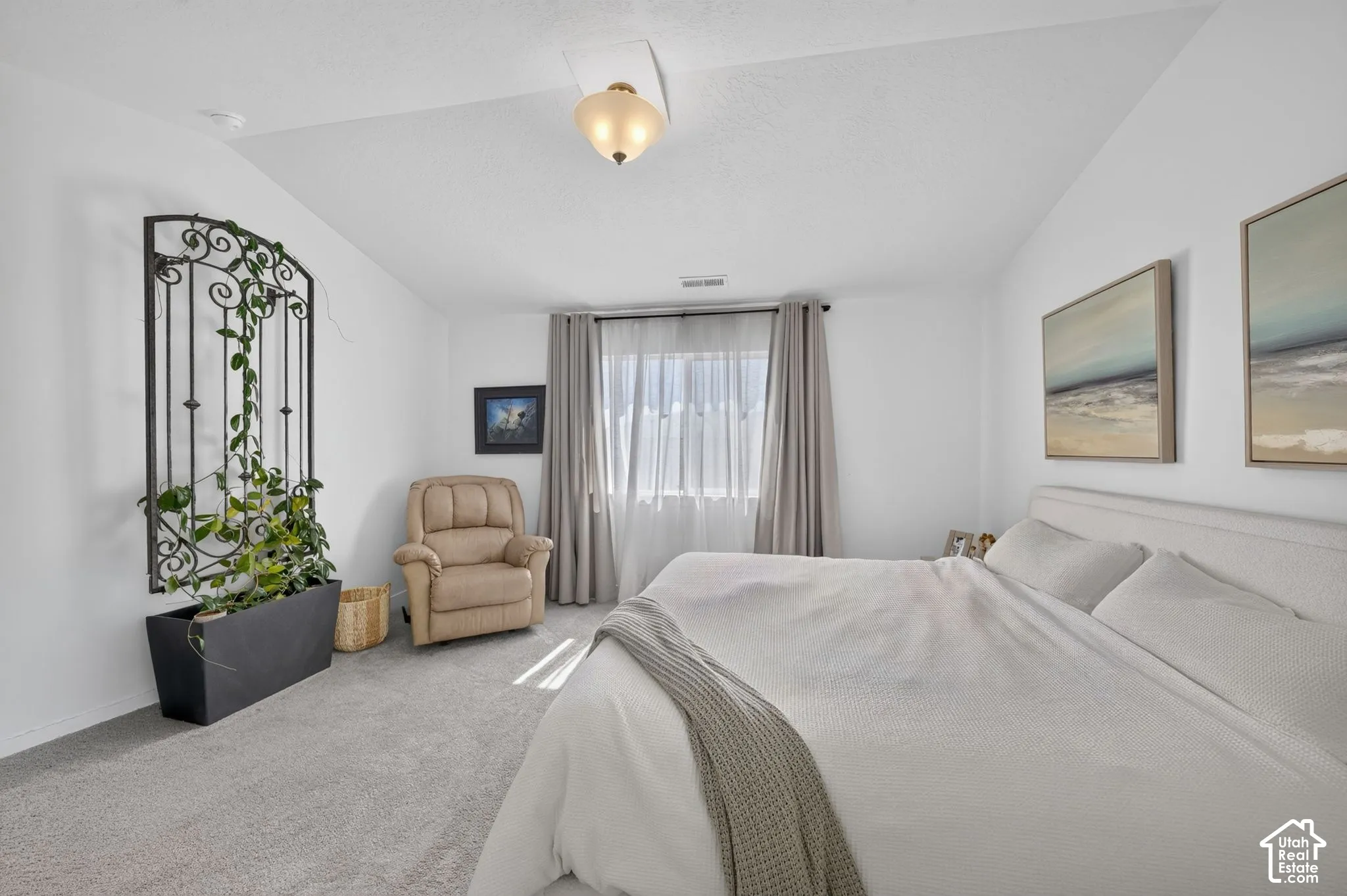 Neutral wall-to-wall carpeting, vaulted ceilings, and a semi-flush mount glass fixture