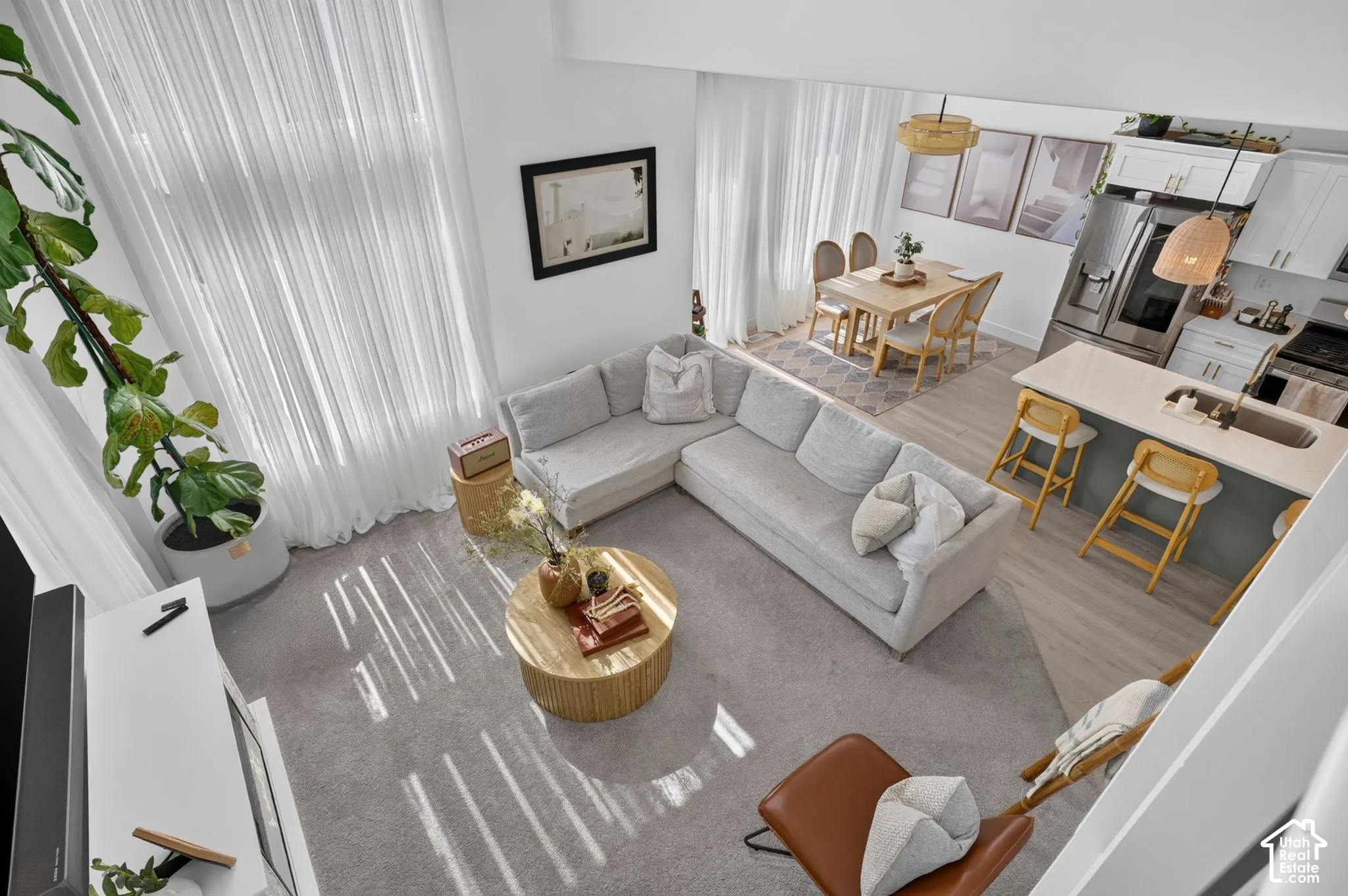 Double-height windows, open-concept floor plan, kitchen featuring a quartz countertop island, built-in cabinetry, and wood-finish flooring