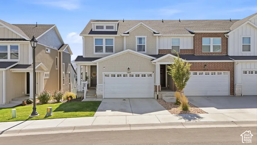 Multi-level exterior featuring a brick and composite siding facade, double-pane windows, a gabled roofline, and an attached two-car garage
