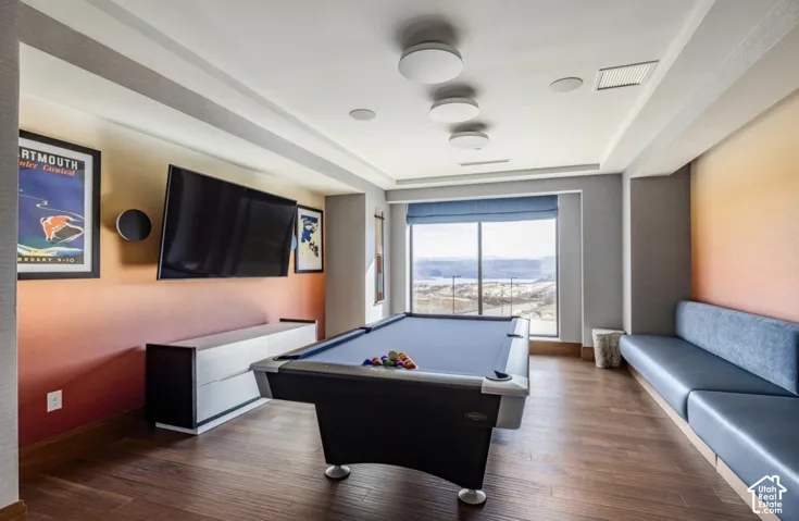 Wood-finish flooring, gradient wall treatment, recessed ceiling lighting, built-in bench seating, and expansive window with mountain scenery