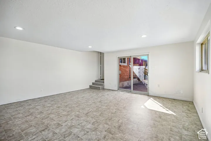 Open floor plan featuring recessed lighting, tile flooring, and glass sliding doors