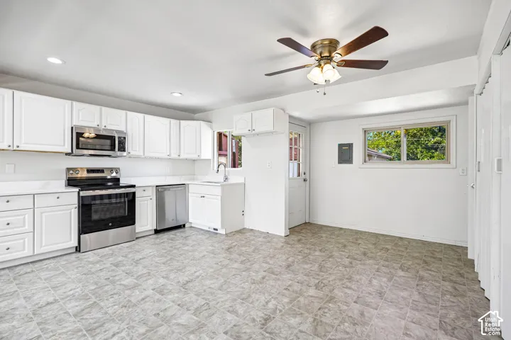 Kitchen featuring white cabinetry, solid-surface countertops, stainless steel appliances, recessed lighting, and a ceiling fan