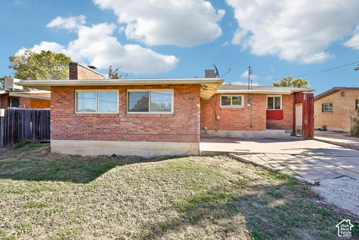 Brick exterior, concrete patio, masonry chimney, and horizontal sliding windows