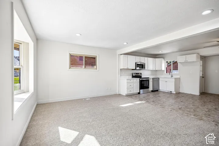 Kitchen featuring white shaker-style cabinetry, stainless steel appliances, and solid surface countertops