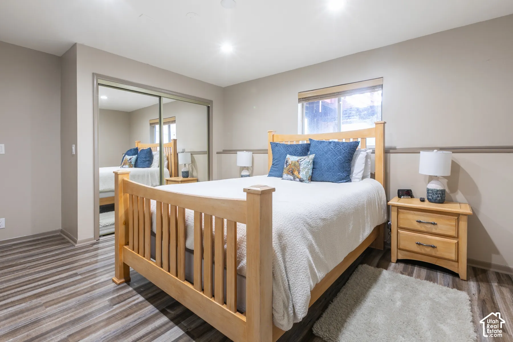 Room featuring wood-finish flooring, recessed lighting, chair rail molding, and a closet with mirrored sliding doors