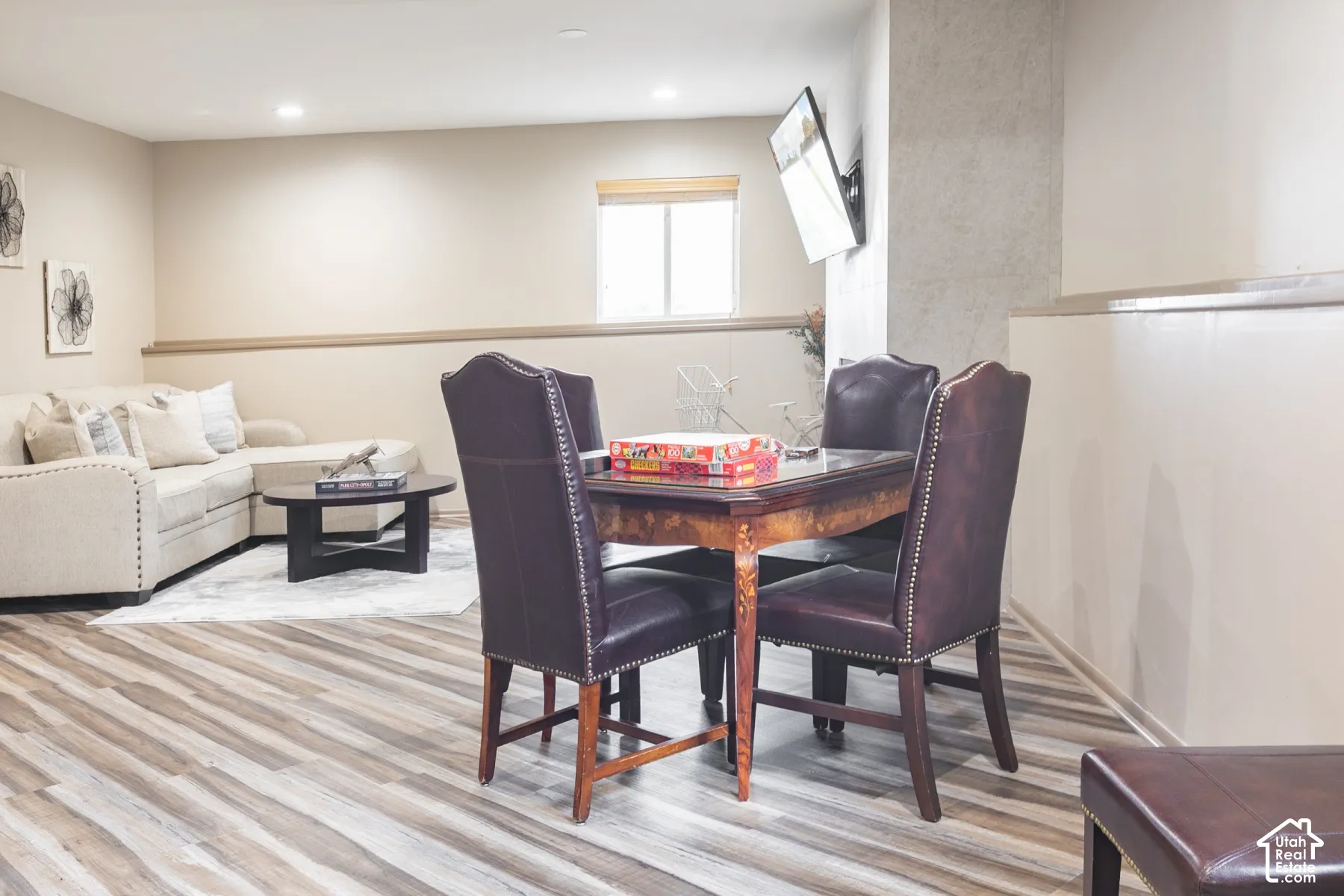 Open-concept room featuring wood-finish flooring, recessed lighting, neutral wall paint, a chair rail, and a large vertical hearth surround
