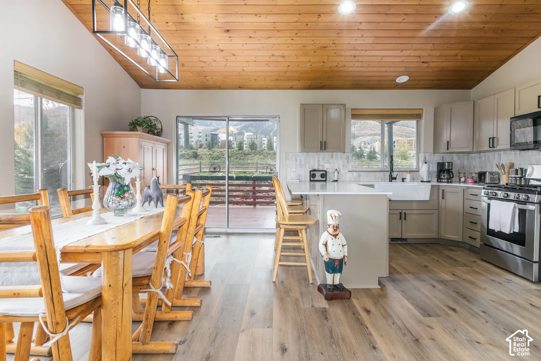 Kitchen featuring a wood-plank vaulted ceiling, wood-finish flooring, white stone-surface countertops, custom cabinetry, and an apron-front sink