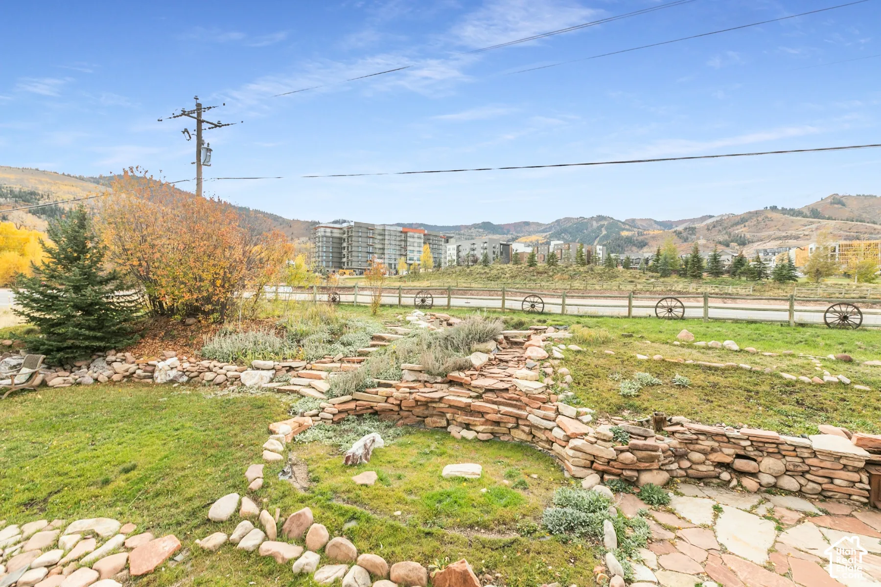 Outdoor space featuring stone terracing, flagstone hardscaping, manicured lawn, and mountain surroundings