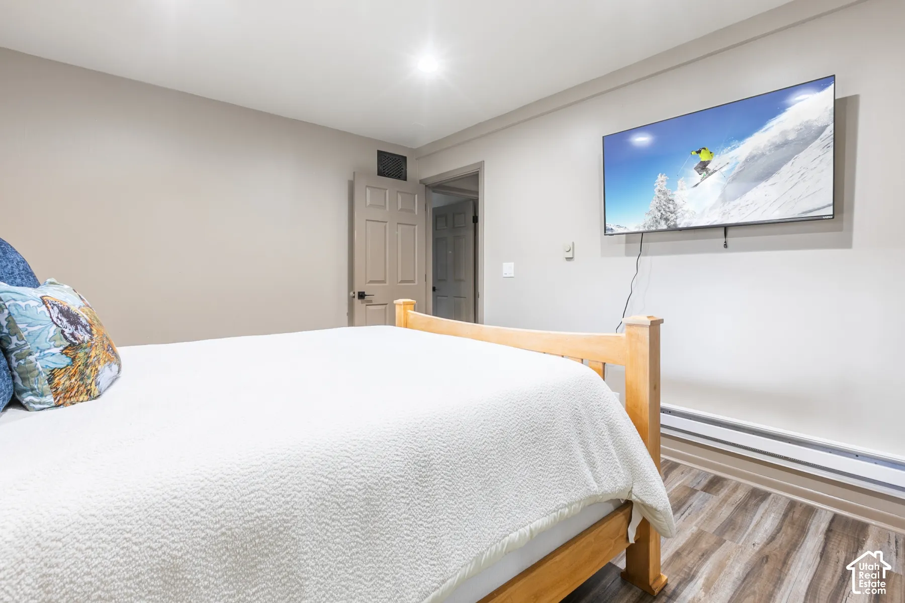 Room featuring wood-finish flooring, recessed lighting, and a six-panel interior door