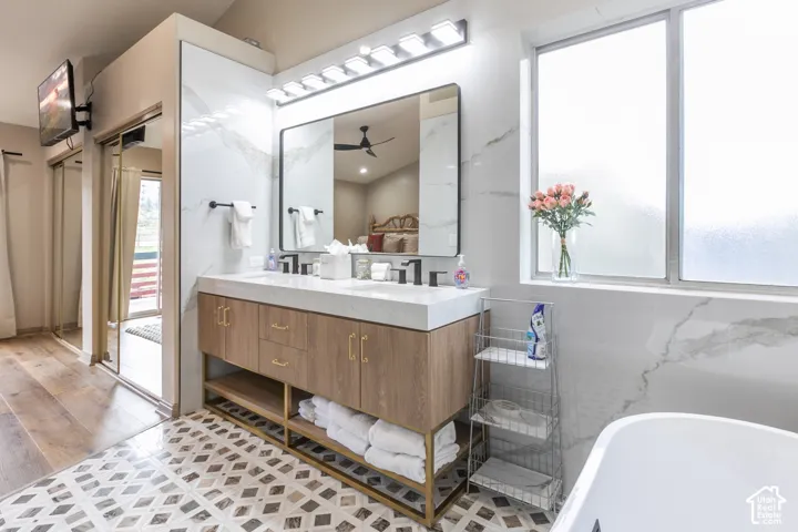 Double vanity with wood-finish cabinetry, metal frame base, white countertop, and matte black fixtures